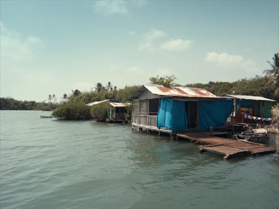 Wooden stilt houses over calm turquoise water in Bocas del Toro